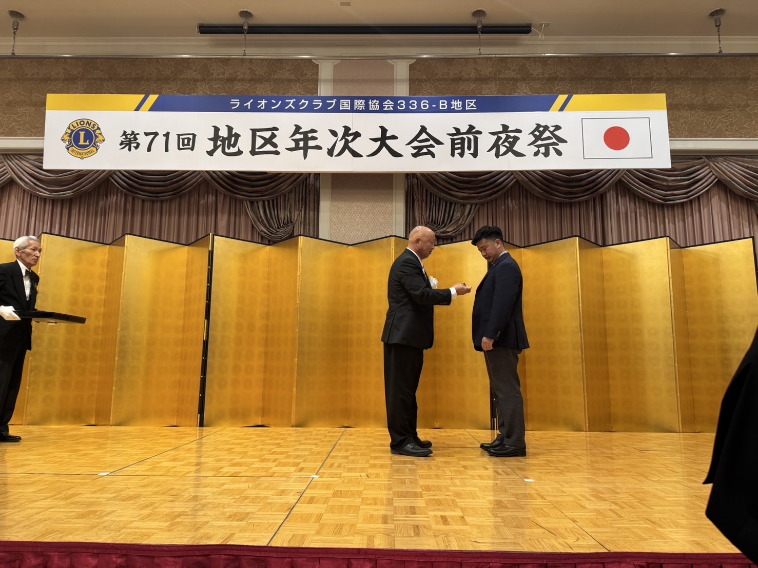 上原正樹ガバナーから上原太一会長へのピンバッジ贈呈シーン